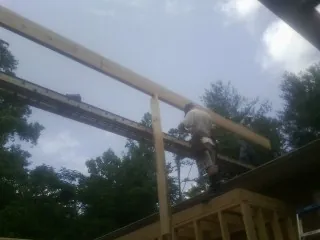 Carpenter setting a ridge beam over a new addition frame — Ice Dam Removal by Roofing Brothers in Stewartstown