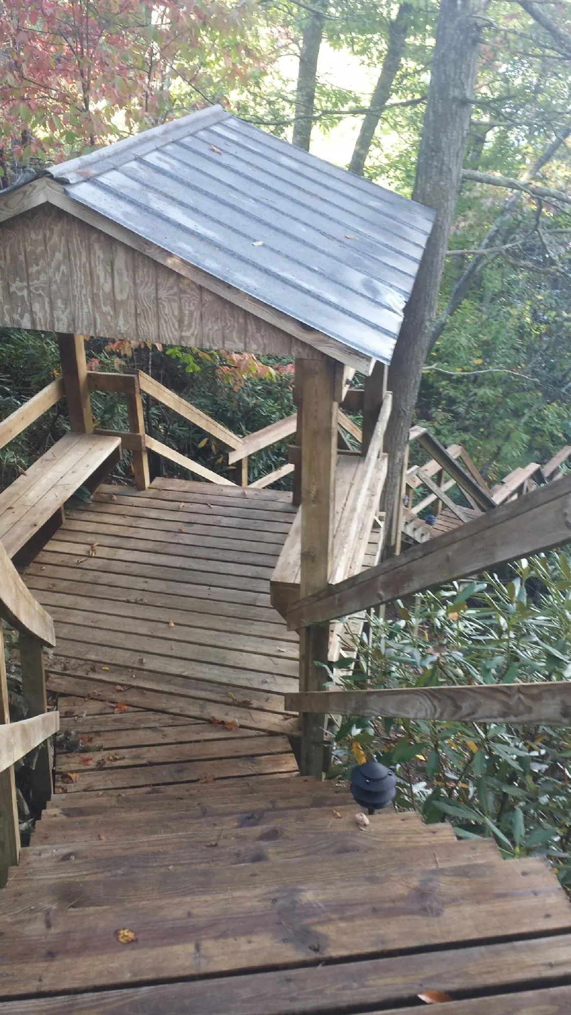 Metal roofed shelter over wooden steps on a wooded walkway — Skylight Repair & Installation work by our crew in Stewartstown