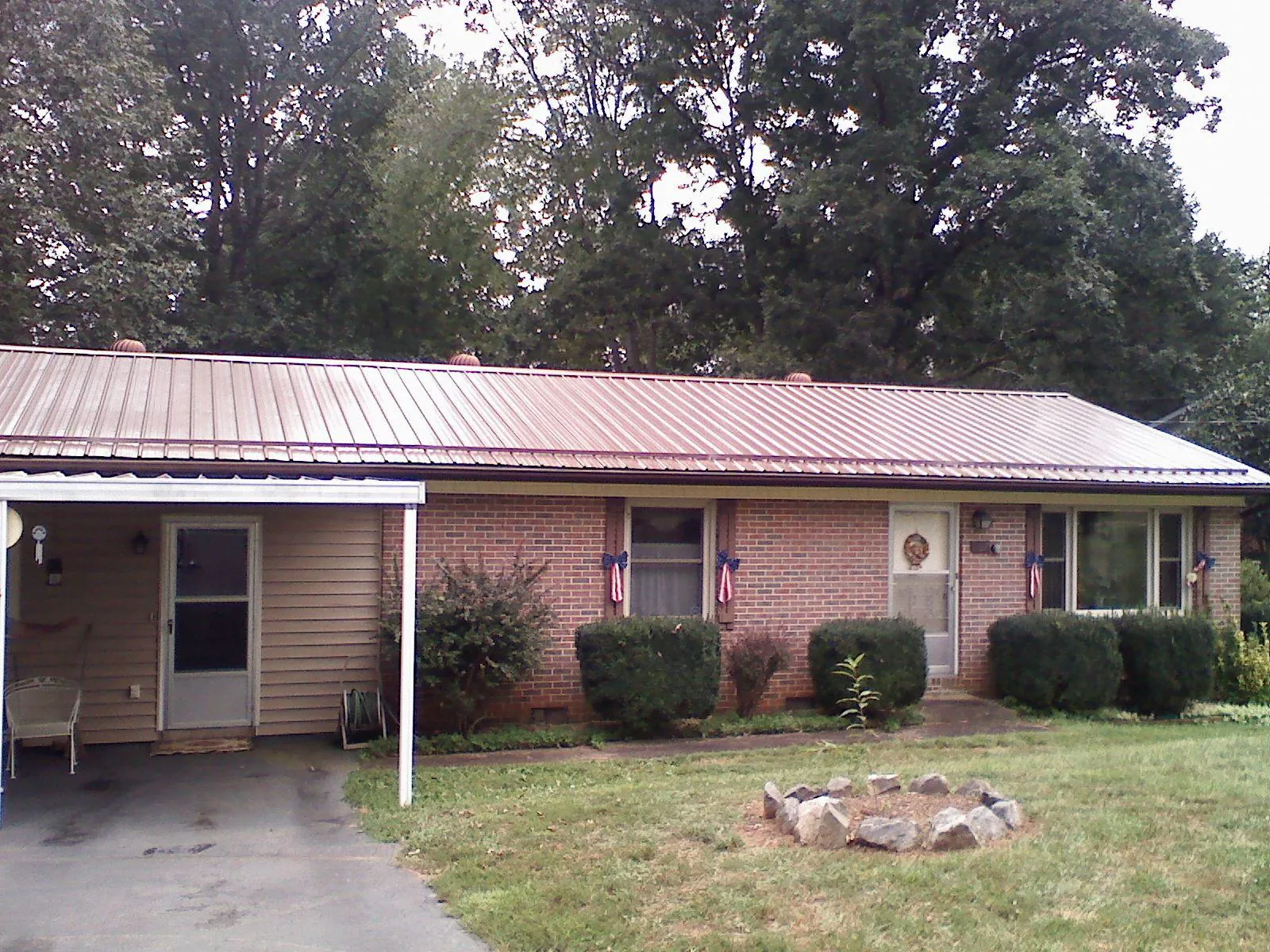 Bronze metal roof and carport on a brick ranch home — Roof Repair work by our crew in Stewartstown